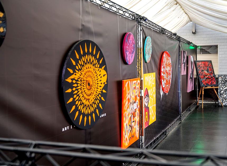 Artwork hung on a black graphic wall inside a black lattice frame