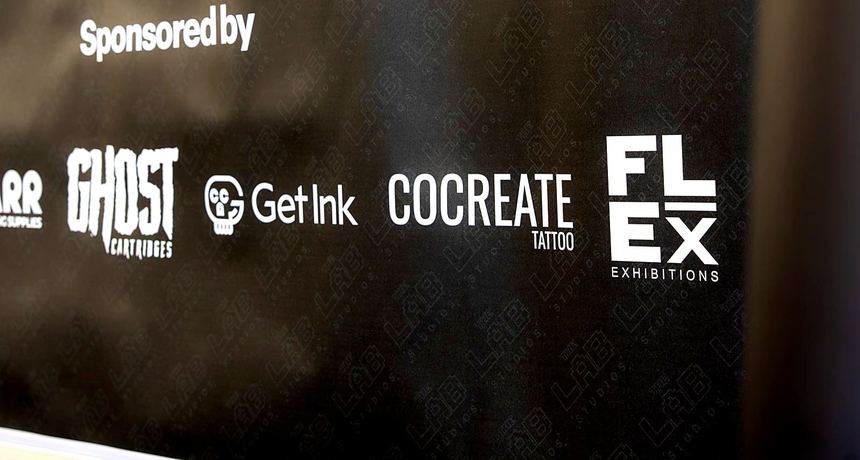 Sponsor board printed on a black graphic panel with the FLEX Exhibitions logo