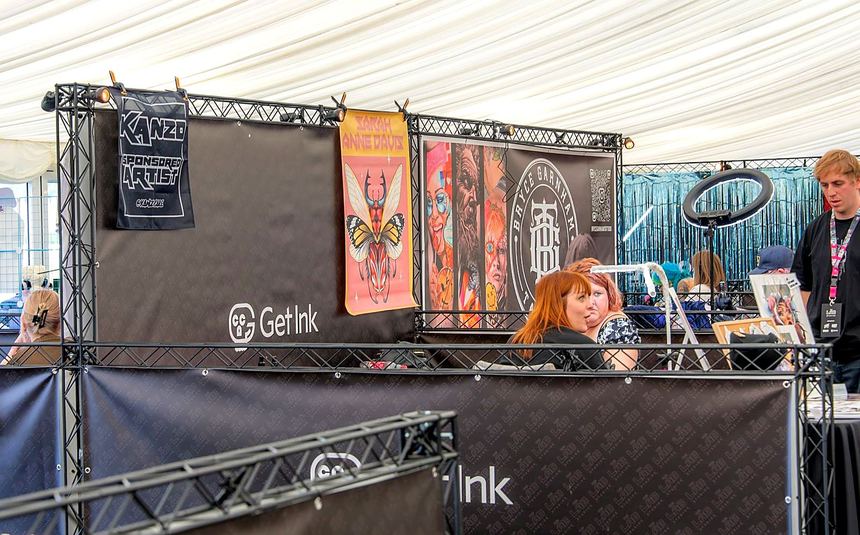 An exhibitor's stand trading, with black graphics and their own branding
