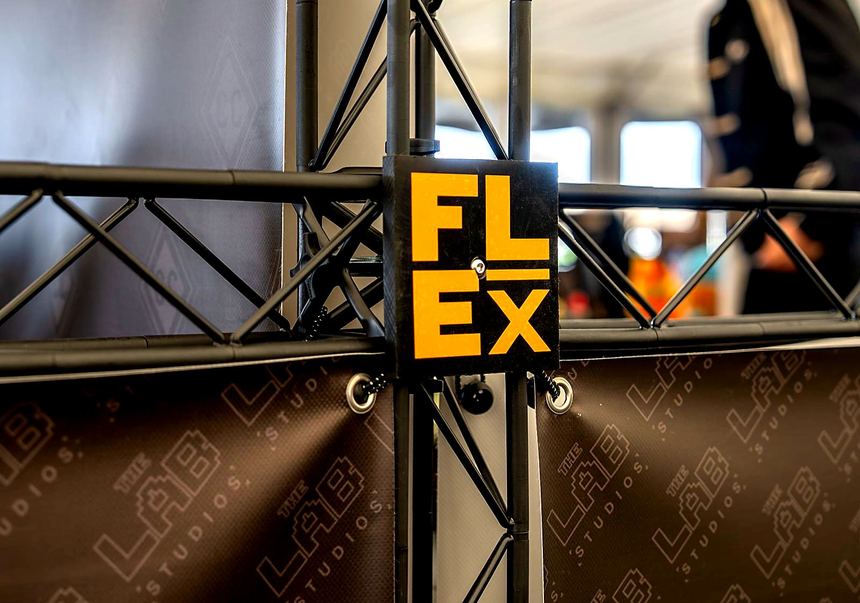 Close-up of a black lattice frame corner with a small orange FLEX tag